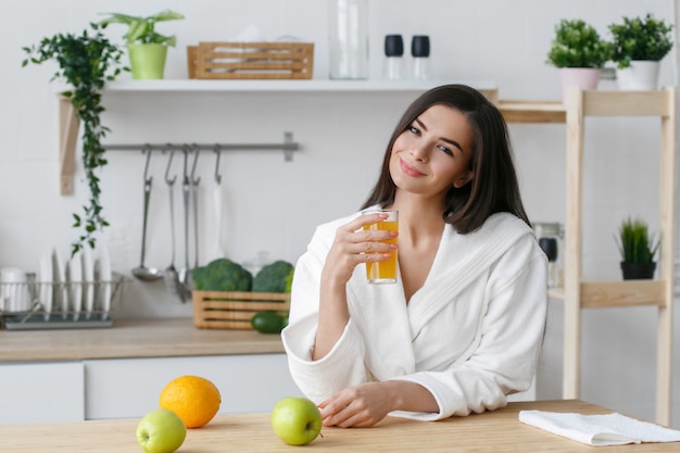 Donna sulla casa della cucina con la cottura delle verdure verdi. Vitamine di dieta domestica sana dell'alimento giovane e bella femmina. Colpo dello studio.