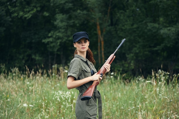 Donna sulla natura Con le braccia in mano un berretto nero è uno stile di vita tute verdi sullo sfondo della foresta