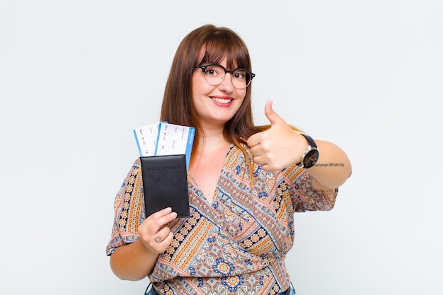 Donna taglie forti che si sente orgogliosa, spensierata, sicura e felice, sorridendo positivamente con i pollici in su