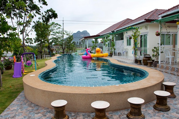 Donna tailandese asiatica che gioca e nuota gomma giocattolo animale che galleggia sull'acqua della piscina al resort in Thailandia