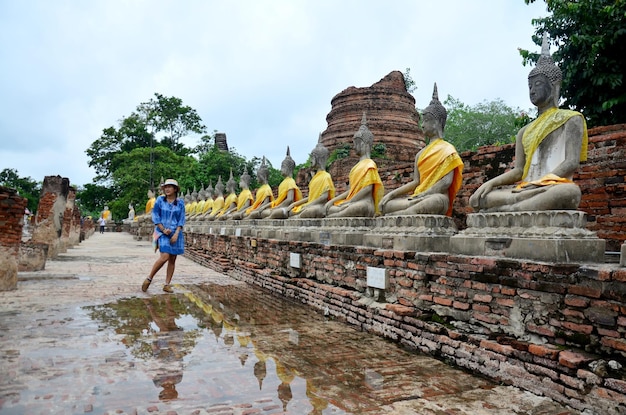 Donna tailandese indossare abiti mauhom ritratto con statua di buddha di Wat Yai chaimongkol ad Ayutthaya in Thailandia