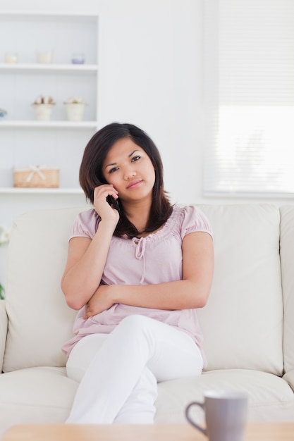 Donna telefonando mentre era seduto su un divano