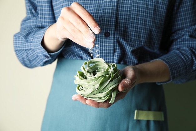 Donna tenere la pasta verde cruda e cospargere di farina