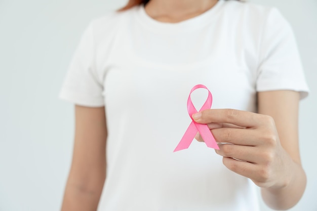 Donna tenere nastro rosa consapevolezza del cancro al seno Controllo sanitario femminile coscienza Giornata internazionale della donna e Giornata mondiale del cancro segno cancro Assistenza sanitaria simbolica supporto diagnosi tempestiva dei pazienti