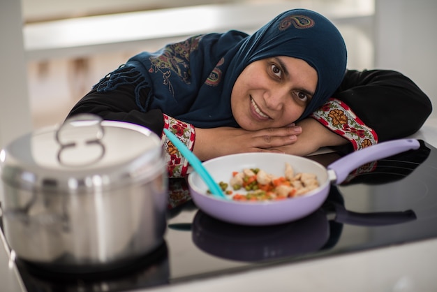 Donna tradizionale musulmana che lavora in cucina