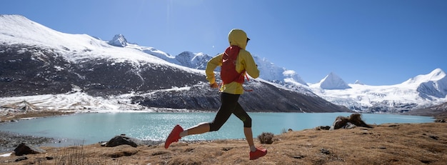 Donna trail runner corsa campestre nella natura invernale ad alta quota