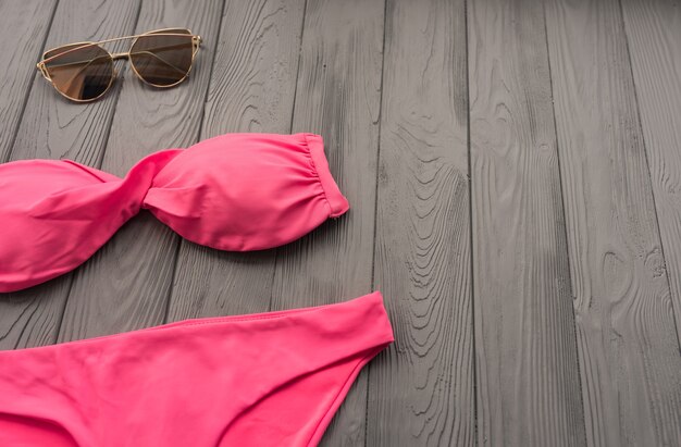 donna trend due pezzi costume da bagno spiaggia rosa moda occhiali da sole. sfondo estivo