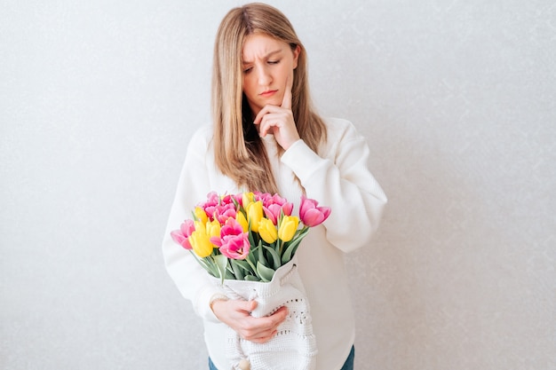 Donna triste che tiene i tulipani