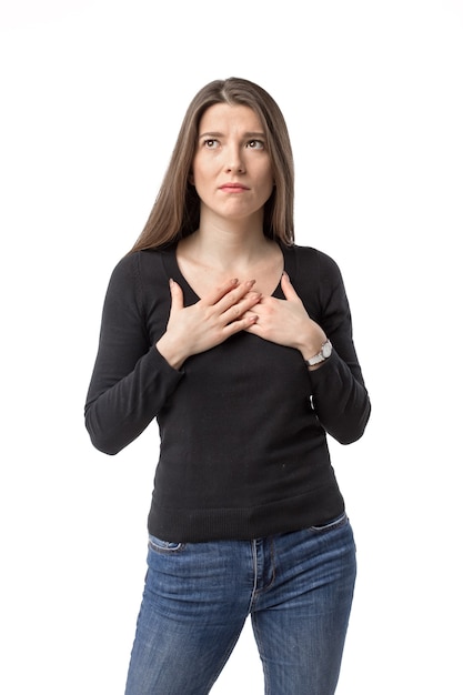 Donna triste piega le braccia sul petto sulla parete bianca dello studio