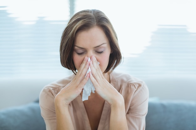 Donna triste sul divano di casa