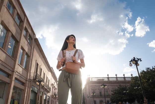 Donna turistica adulta che cammina per la città al tramonto con il sole dietro il concetto di viaggiatore singolo