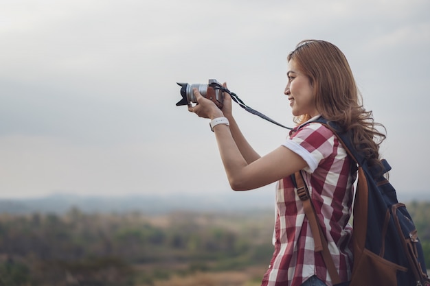 Donna turistica che cattura foto con la sua macchina fotografica in natura