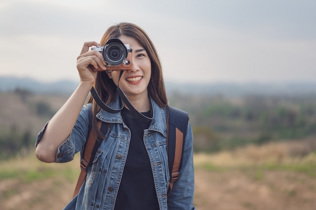 Donna turistica che cattura foto con la sua macchina fotografica in natura