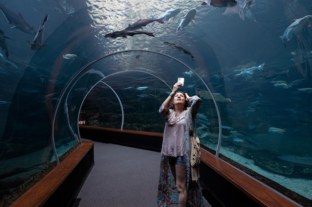 Donna turistica che cattura foto in acquario