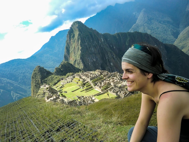 Donna turistica che posa nella cittadella della montagna di Machu Picchu Huayna Picchu a Cusco Perù