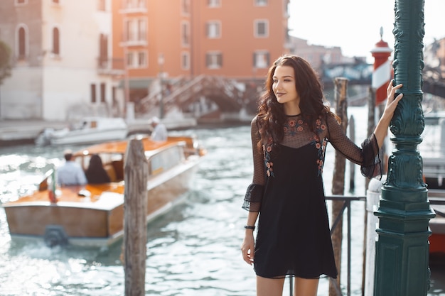 Donna turistica di viaggio sul molo contro la bella vista sul canale veneziano a Venezia, Italia.