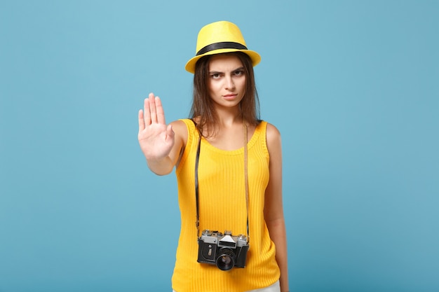 donna turistica in abiti casual estivi gialli e cappello con macchina fotografica su blu