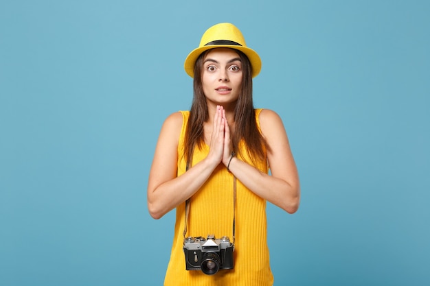 donna turistica in abiti casual estivi gialli e cappello con macchina fotografica su blu