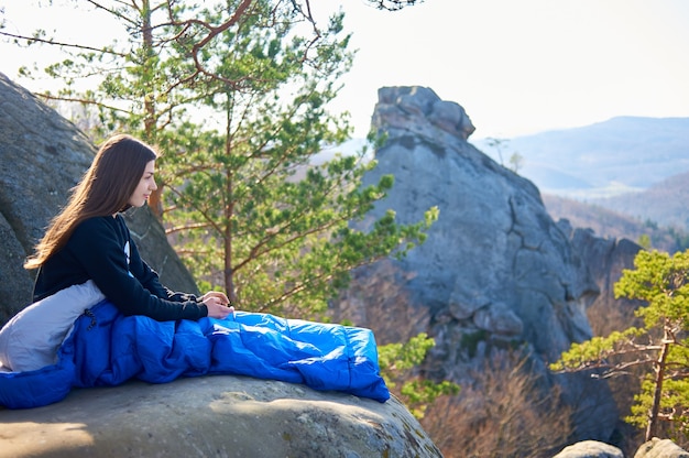 Donna turistica in sacchi a pelo su grandi rocce