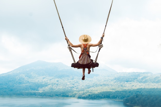 Donna turistica su un'altalena in vacanza a Bali, Indonesia