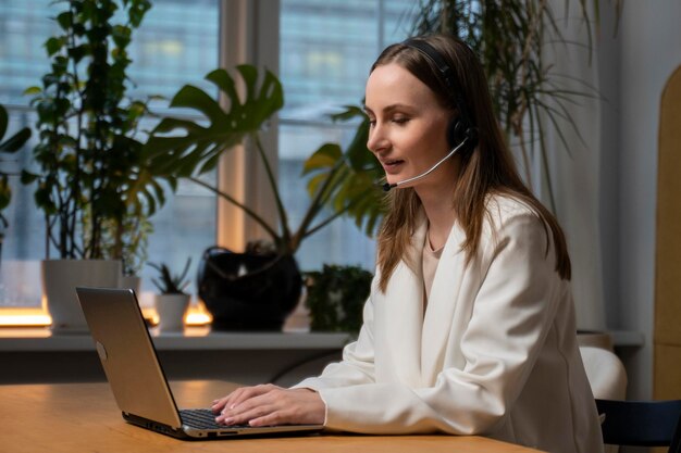 Donna un call center e un computer con un auricolare che consiglia il servizio clienti di telemarketing o offi