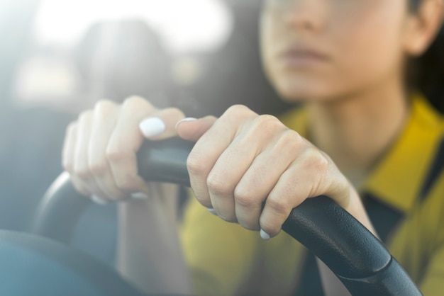 Donna vaga che tiene le sue mani sul volante