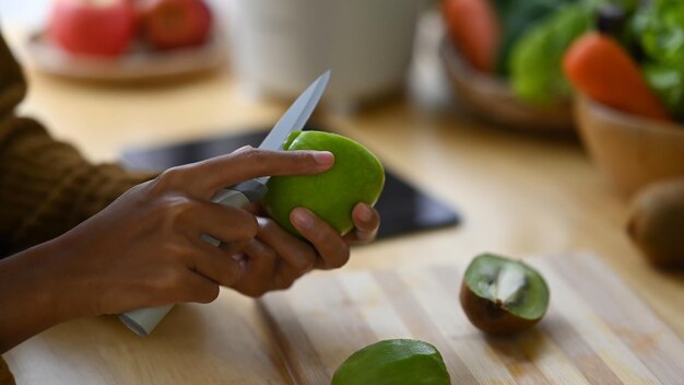 Donna vegetariana ritagliata che prepara cibo vegano sano in cucina