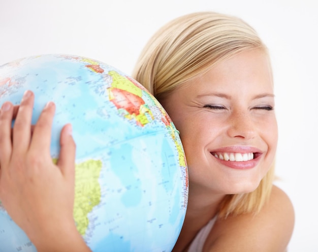 Donna viaggiare e abbracciare il globo con lo studio e felice da festa del giorno della terra o vacanza internazionale sorriso mondo e mappa per l'apprendimento e la geografia con una persona femminile e abbracciamento del pianeta