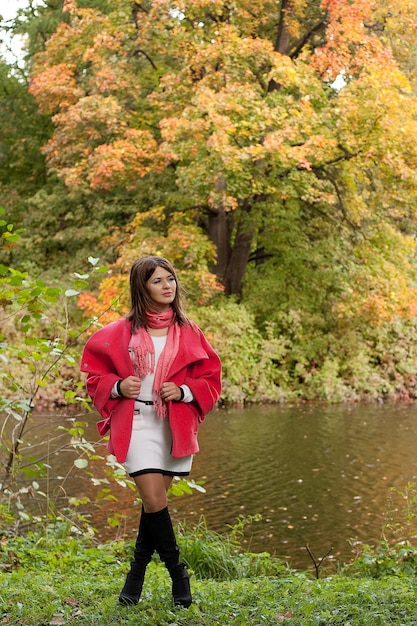 Donna vicino al fiume nella stagione autunnale