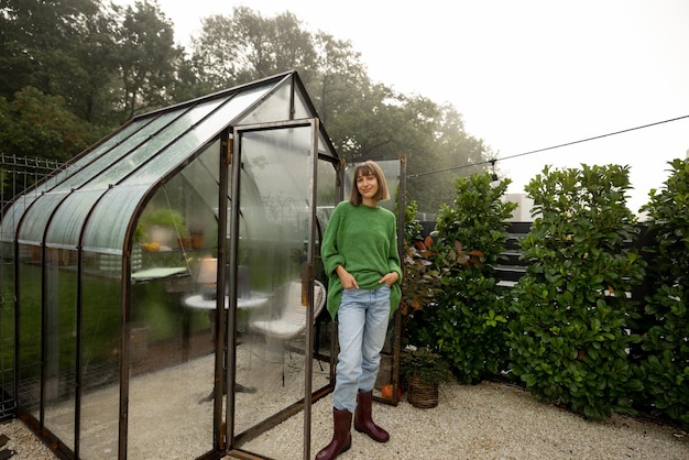 Donna vicino alla serra al cortile