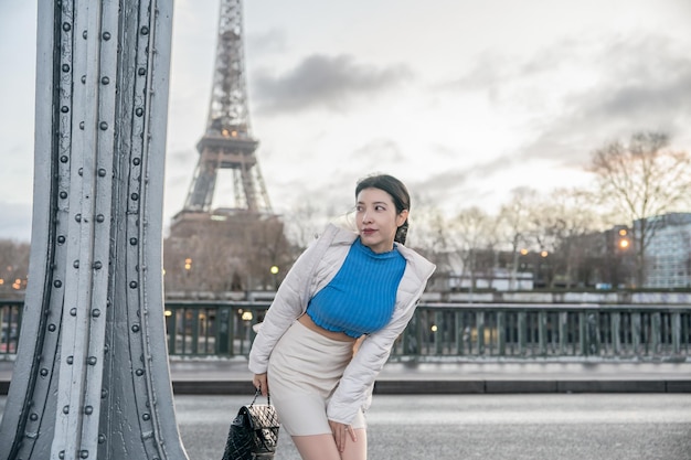 Donna vicino alla Torre Eiffel in una giornata invernale