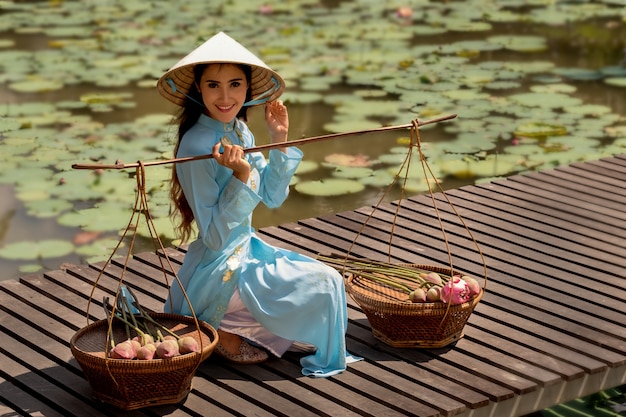 Donna vietnamita con cesto di loto