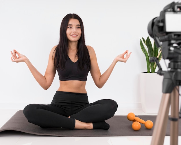 Donna vlogging a casa durante l'allenamento