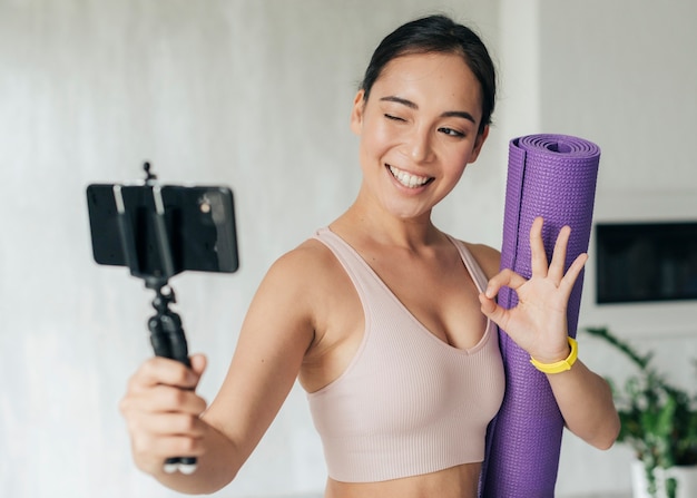 Donna vlogging mentre si tiene il suo tappetino fitness