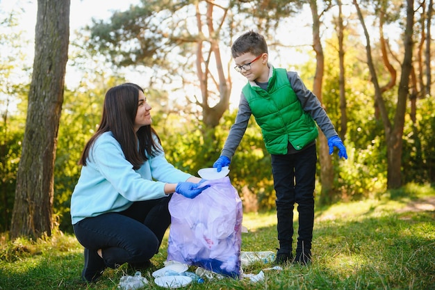 Donna volontaria e bambino che raccolgono la spazzatura di plastica