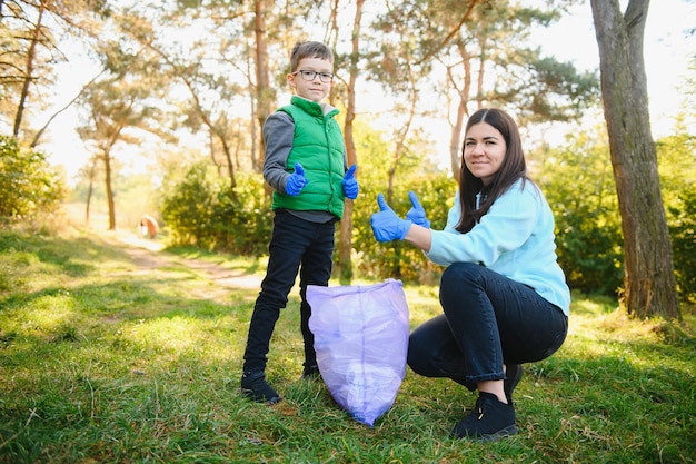 Donna volontaria e bambino che raccolgono la spazzatura di plastica