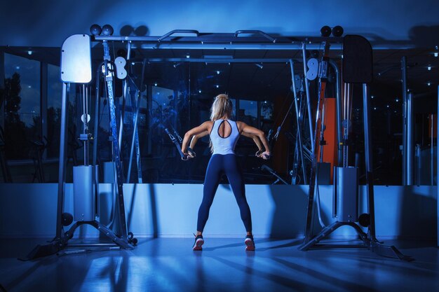 Donna voluttuosa che fa esercizi in palestra vicino allo specchio