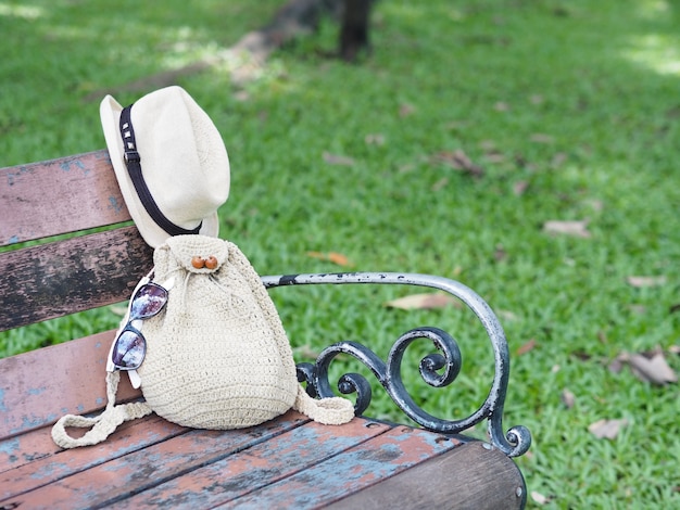 Donne a maglia borsa e cappello sul banco di legno d&#39;epoca nel parco.