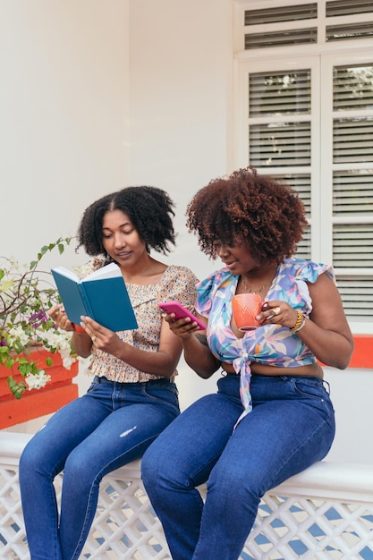 Donne afro che leggono cose mentre bevono caffè