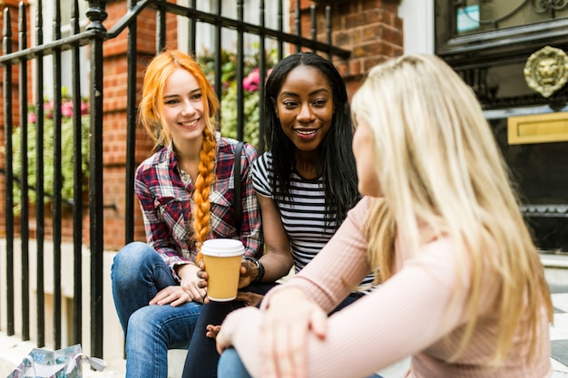 Donne, amici, chiacchierando e sorridendo a Londra