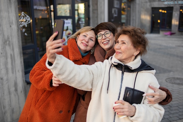 Donne anziane che si fanno un selfie mentre escono per un caffè