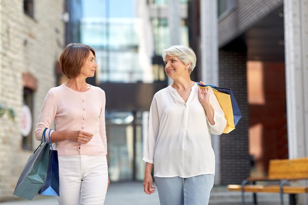 donne anziane con le borse della spesa che camminano in città