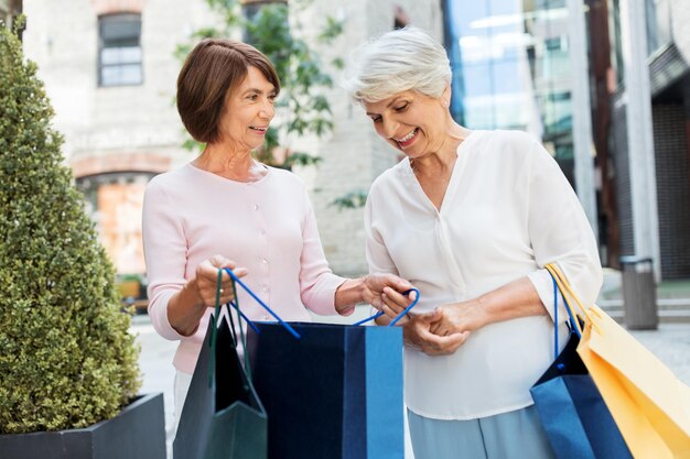 donne anziane con le borse della spesa in città