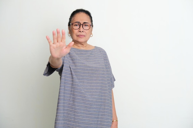 Donne asiatiche anziane che mostrano il segno della mano di arresto con l'espressione seria del viso