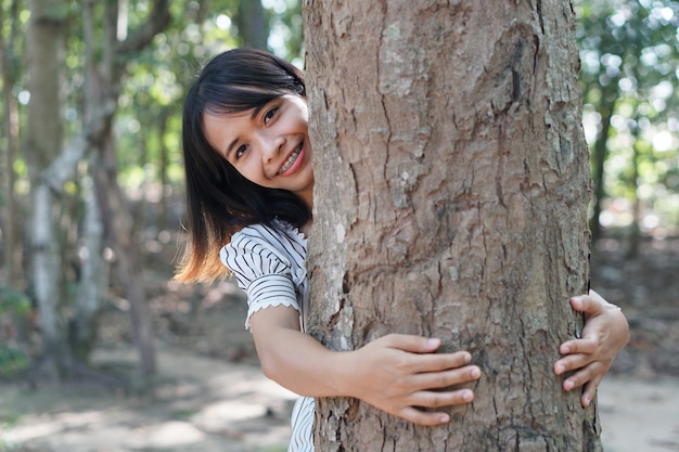 Donne asiatiche che abbracciano gli alberi, concetto di amore per il mondo