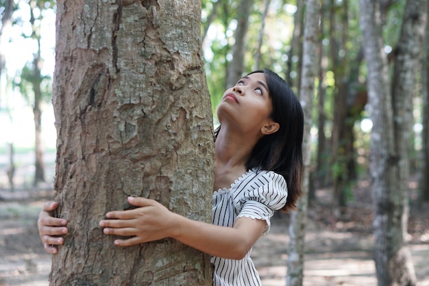 Donne asiatiche che abbracciano gli alberi, concetto di amore per il mondo