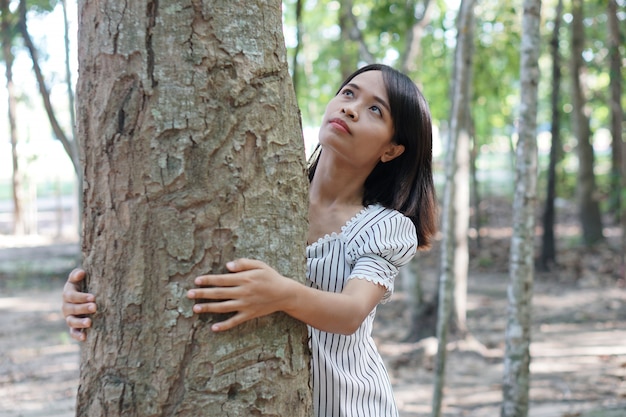 Donne asiatiche che abbracciano gli alberi, concetto di amore per il mondo