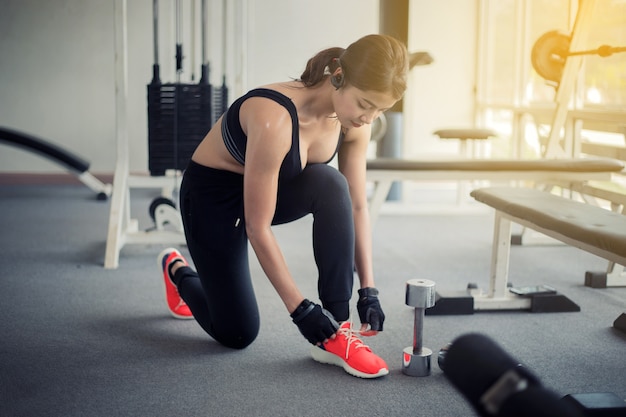 donne asiatiche che legano i lacci delle scarpe. donne di fitness si preparano per impegnarsi in palestra