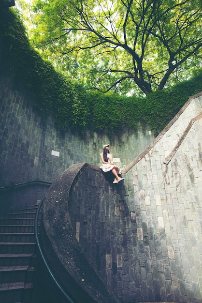 Donne asiatiche con la scala a chiocciola a Canning Park forte, Singapore