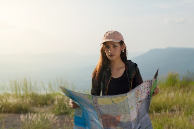 donne asiatiche con zaino luminoso guardando una mappa. Vista dalla parte posteriore del viaggiatore turistico sul backgro